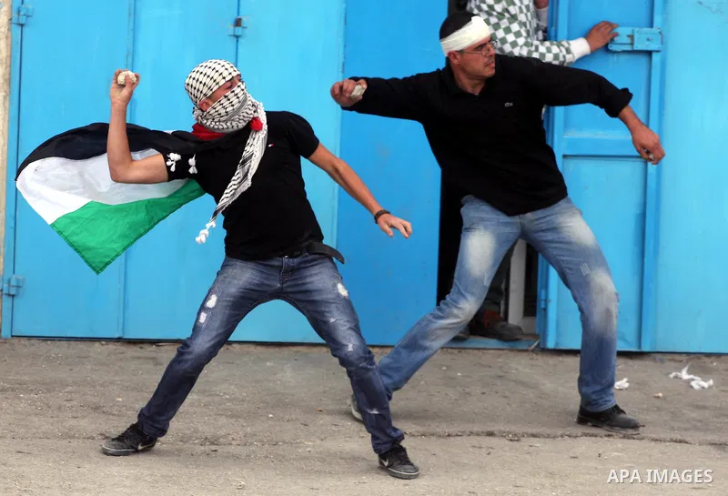 Palestinian youths throw stones during clashes with Israeli soldiers at the Israeli manned Qalandia checkpoint between Jerusalem and the West Bank city of Ramallah on May 15, 2011. Palestinians across the Israeli occupie...