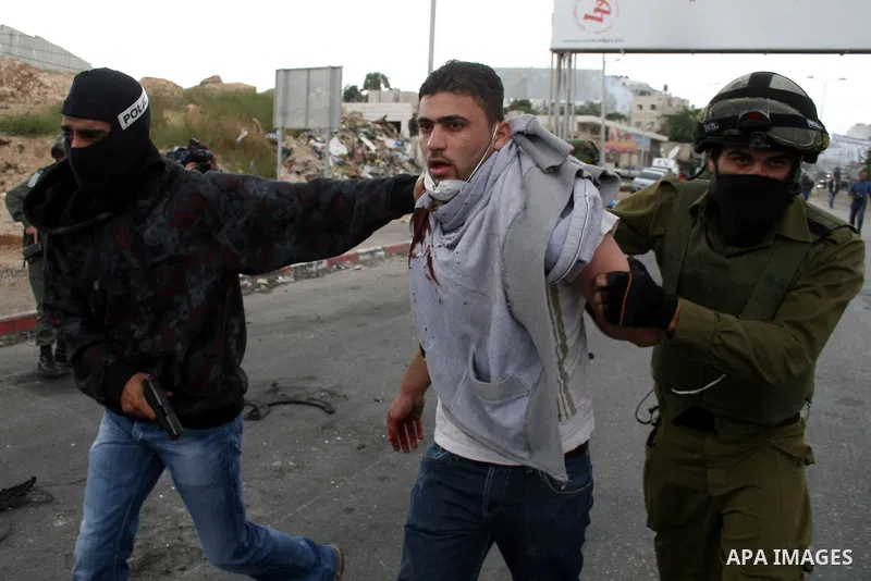 An Israeli soldier and undercover police arrest a Palestinian man during clashes with stone throwers at the Israeli manned Qalandia checkpoint between Jerusalem and the West Bank city of Ramallah on May 15, 2011. Palesti...