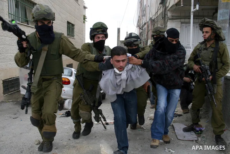 An Israeli soldier and undercover police arrest a Palestinian man during clashes with stone throwers at the Israeli manned Qalandia checkpoint between Jerusalem and the West Bank city of Ramallah on May 15, 2011. Palesti...