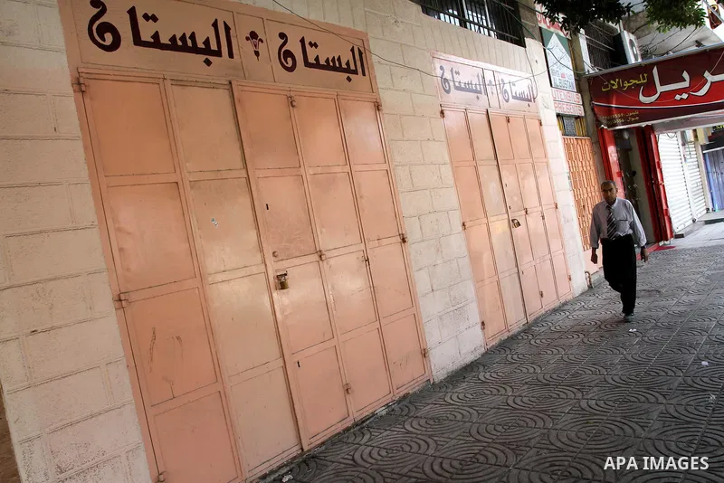 Palestinians walk passed closed shops during a general strike in Gaza Strip on May 16, 2011, to mourn for what israeli occupation done yesterday of shedding the blood of the citizens and Suppression rights of journalists...