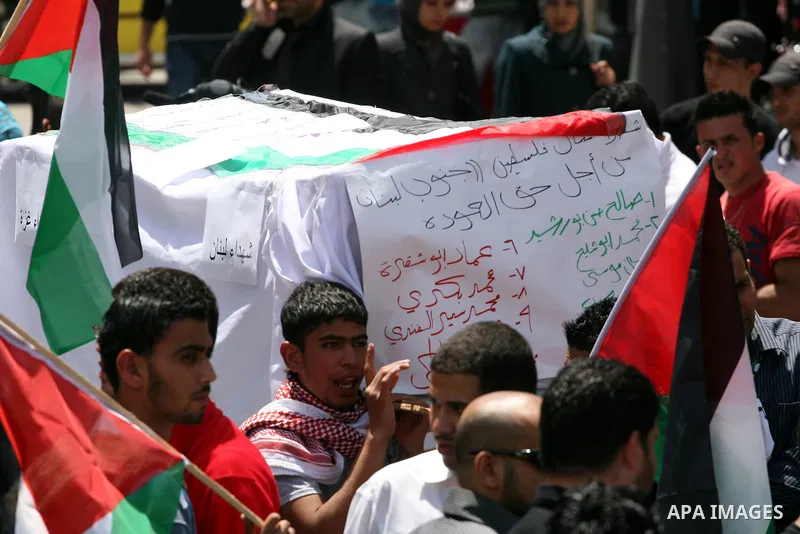 Palestinians in the West Bank city of Ramallah carry a mock coffin during a symbolic funeral on May 16, 2011 for those killed during clashes which erupted as Palestinians and Arab Israelis demonstrated to mark the annive...