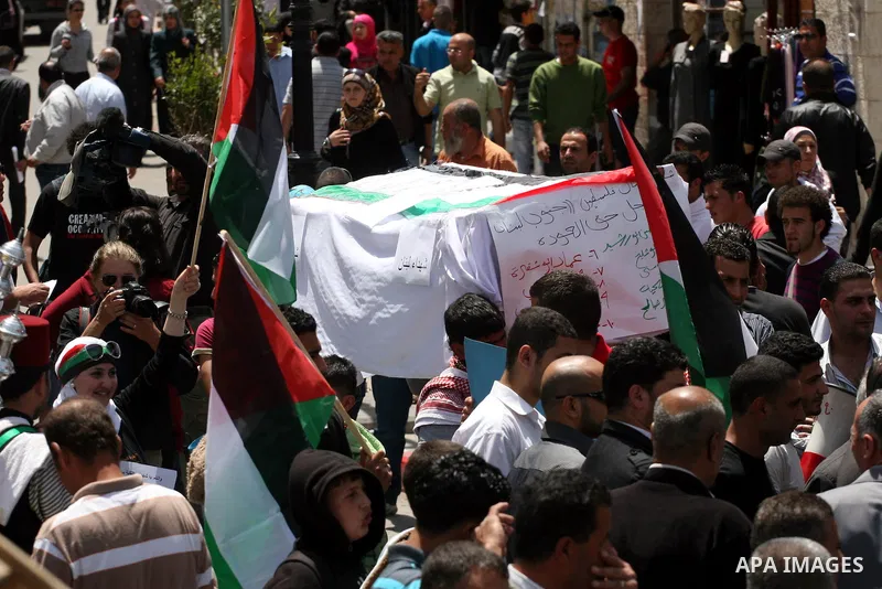 Palestinians in the West Bank city of Ramallah carry a mock coffin during a symbolic funeral on May 16, 2011 for those killed during clashes which erupted as Palestinians and Arab Israelis demonstrated to mark the annive...