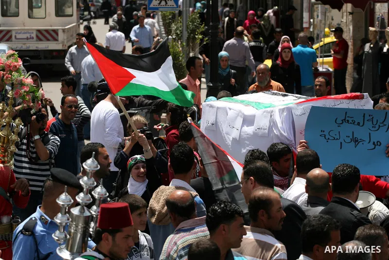 Palestinians in the West Bank city of Ramallah carry a mock coffin during a symbolic funeral on May 16, 2011 for those killed during clashes which erupted as Palestinians and Arab Israelis demonstrated to mark the annive...