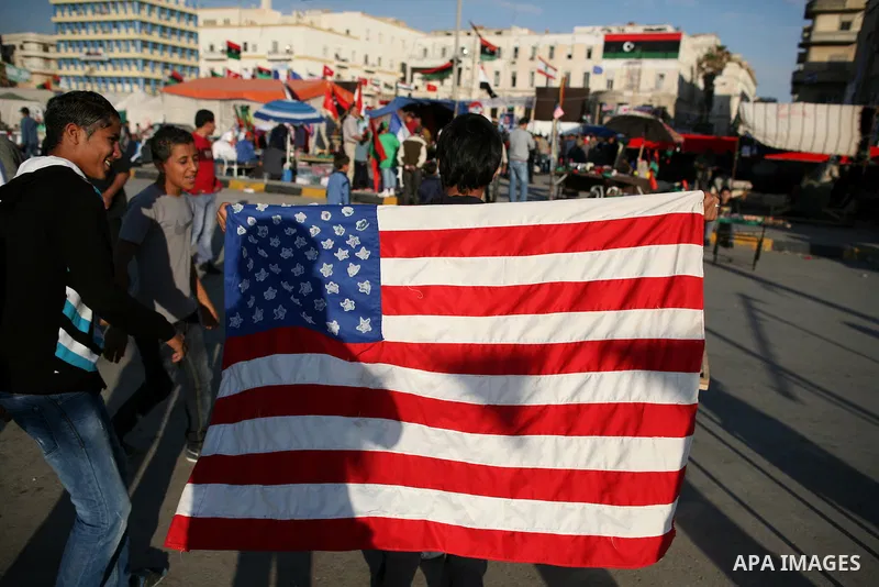 A Libyan youth holds US flag at a market in the eastern rebel stronghold of Benghazi on May 17, 2011 Photo by Wissam Nassar