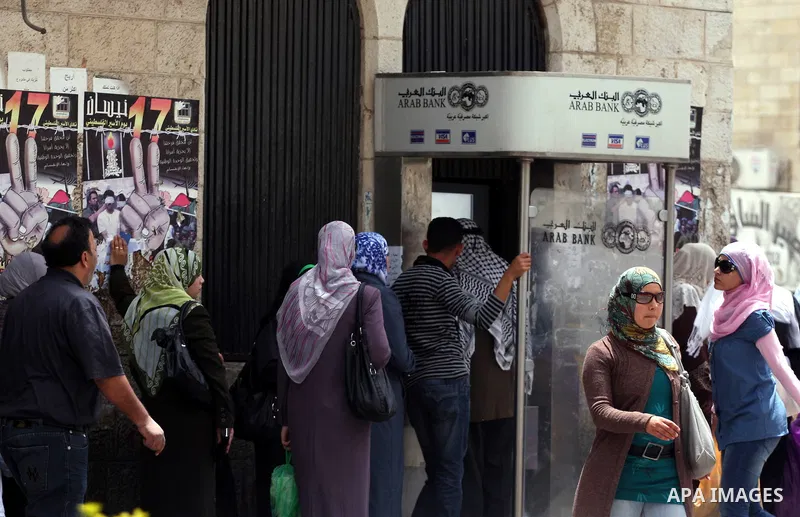Palestinians receive their salaries for the month of May through ATMs banks in the West Bank city of Ramallah on May 17, 2011, as Palestinian Authority delayed to pay salaries for this month after Israel banned in paymen...