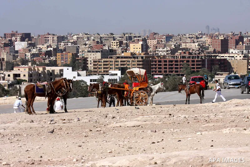 Foreign tourists ride horses and Rockaway near the Giza Pyramids at the outskirts of Cairo, capital of Egypt. in this picture taken May 11, 2011. Photo by Ashraf Amra