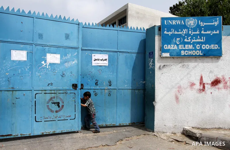 Palestinian boy stands in front of United Nations Relief and Works Agency (UNRWA) closed school in Gaza City May 18, 2011 as UN Palestinian employees stage a one day-strike demanding higher wages. Some 16 thousand Palest...