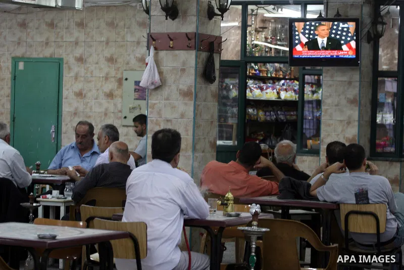 Palestinians watch TV in the West Bank city of Ramallah as the US President Barack Obama speaks on the events in the Middle East and North Africa at the State Department in Washington, DC, May 19, 2011. Obama said that t...