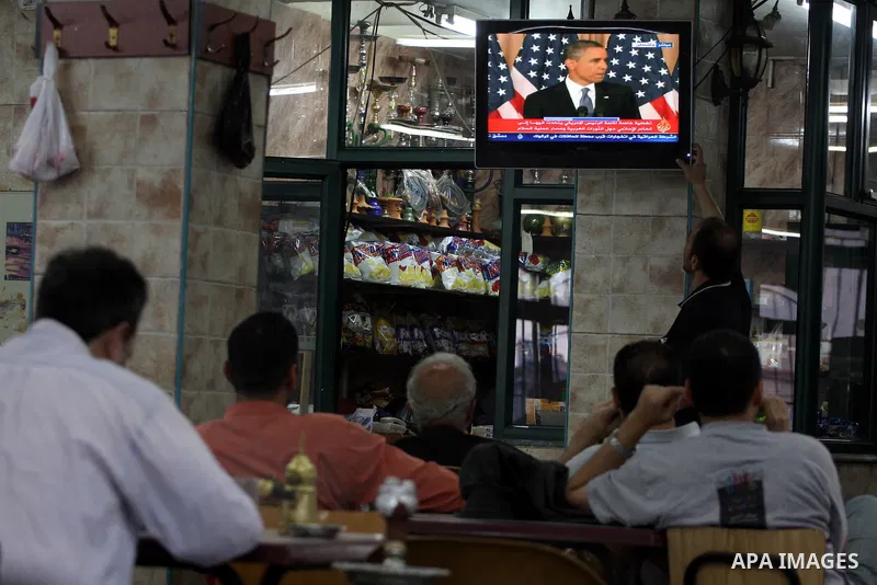 Palestinians watch TV in the West Bank city of Ramallah as the US President Barack Obama speaks on the events in the Middle East and North Africa at the State Department in Washington, DC, May 19, 2011. Obama said that t...