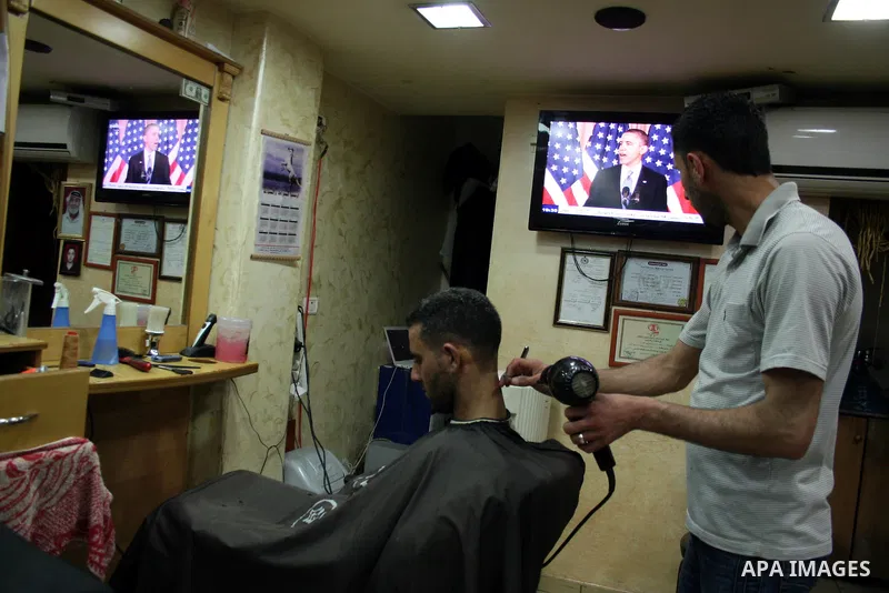 Palestinians watch TV in the West Bank city of Ramallah as the US President Barack Obama speaks on the events in the Middle East and North Africa at the State Department in Washington, DC, May 19, 2011. Obama said that t...