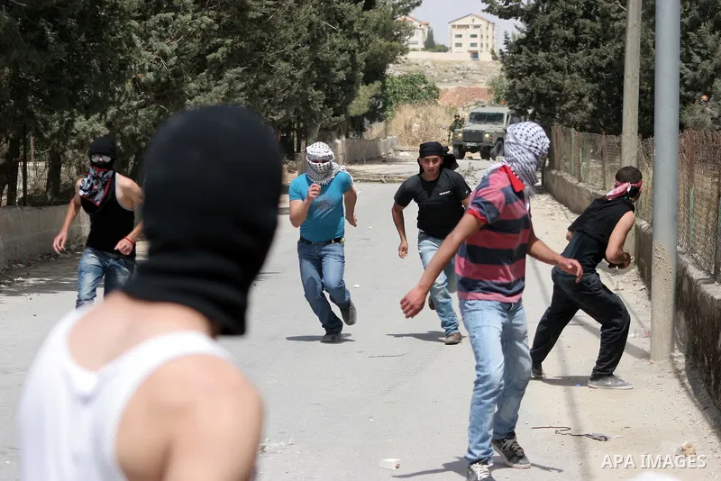 Masked Palestinian demonstrators hurl stones toward Israeli soldiers during a demonstration in the West Bank village of Al-khader near Bethlehem, Friday, May 20, 2011. President Barack Obama on Thursday finally uttered t...