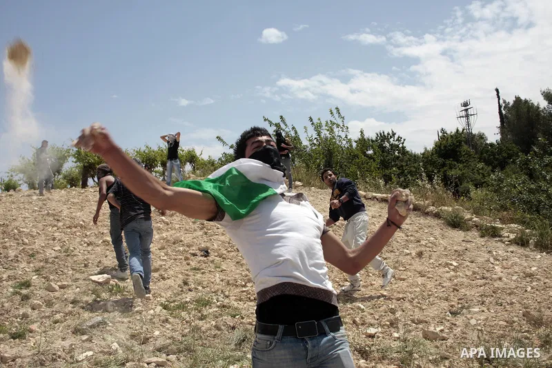 Masked Palestinian demonstrators hurl stones toward Israeli soldiers during a demonstration in the West Bank village of Al-khader near Bethlehem, Friday, May 20, 2011. President Barack Obama on Thursday finally uttered t...