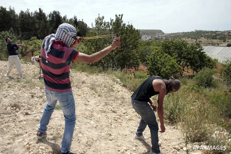 Masked Palestinian demonstrators hurl stones toward Israeli soldiers during a demonstration in the West Bank village of Al-khader near Bethlehem, Friday, May 20, 2011. President Barack Obama on Thursday finally uttered t...