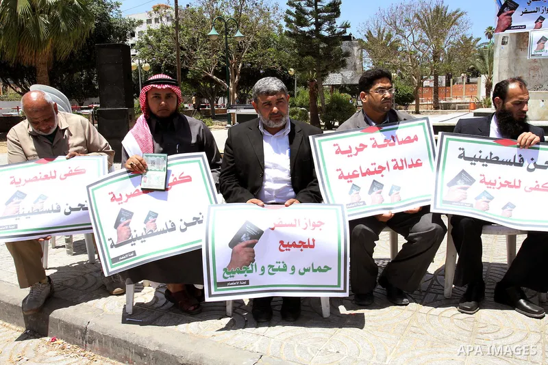 Palestinian protesters hold banners during an effectiveness to prevent them from obtaining passports by Ramallah, in Gaza city on May 21, 2011. Palestinians condemn it , and raise slogans against the political partisansh...