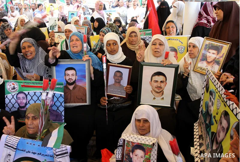 Palestinians hold pictures of their jailed relatives during a rally, at the headquarters of the Red cross calling for the release of Palestinian prisoners from Israeli jails, in Gaza city on May 23, 2011. Photo by Mohamm...