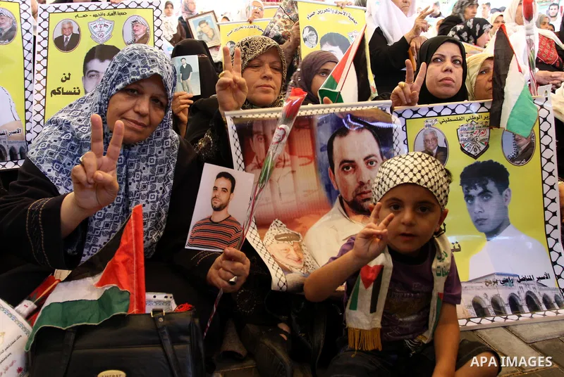 Palestinians women and children hold pictures of their jailed relatives during a rally, at the headquarters of the Red cross calling for the release of Palestinian prisoners from Israeli jails, in Gaza city on May 23, 20...