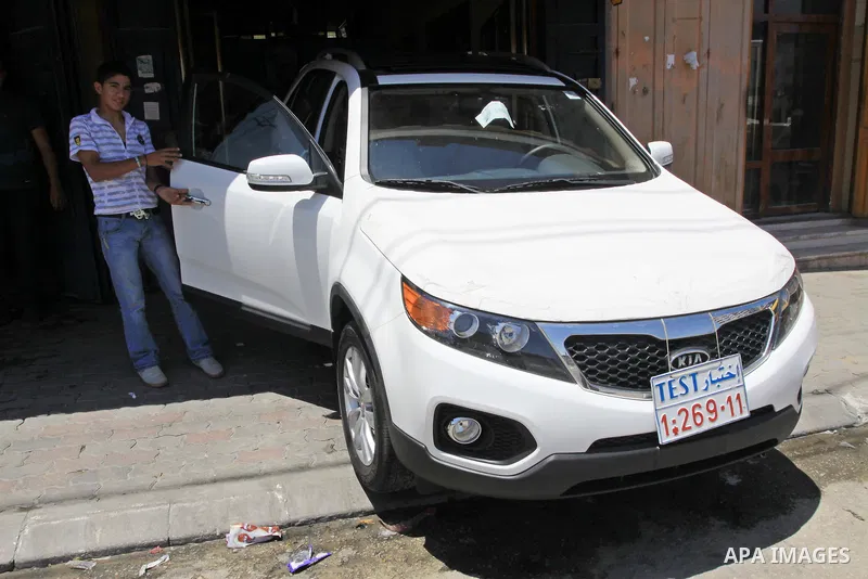 Palestinians watch a new car that Israel recently allowed into Gaza, at a showroom in Gaza City, on May 23, 2011. Luxury cars with Libyan plates are becoming a common sight in the Gaza Strip, in a surprising side-effect...