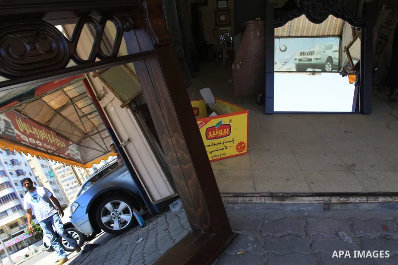 Palestinians watch a new car that Israel recently allowed into Gaza, at a showroom in Gaza City, on May 23, 2011. Luxury cars with Libyan plates are becoming a common sight in the Gaza Strip, in a surprising side-effect...