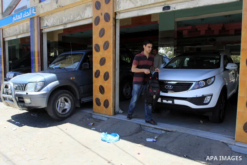 Palestinians watch a new car that Israel recently allowed into Gaza, at a showroom in Gaza City, on May 23, 2011. Luxury cars with Libyan plates are becoming a common sight in the Gaza Strip, in a surprising side-effect...