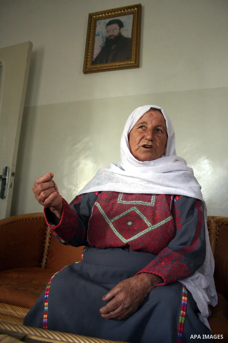 Aisha Aruri, mother of Salah Aruri (portrait top), a senior member of Hamas exiled in Syria, speaks to the press after she was released from a 24-hours Israeli detention in the West Bank city of Ramallah on May 24, 2011....