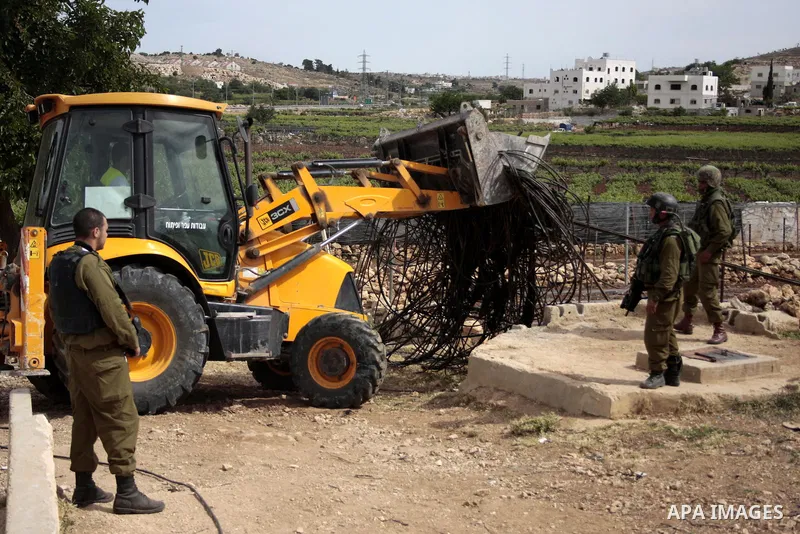 Israeli soldiers stand guard destroy agriculture land partially near the West Bank City of Hebron across the road from the Israeli settlement of Kiryat Arba on May 25, 2011. as a response to last week's speech by US Pres...
