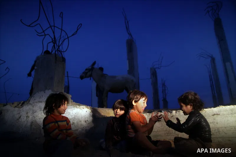 Palestinian children play outside a tent which was erected outside their family house in Jabaliya refugee camp, in the northern Gaza Strip, 24 May 2011. Their house was destroyed during the Israeli assault on Gaza in lat...