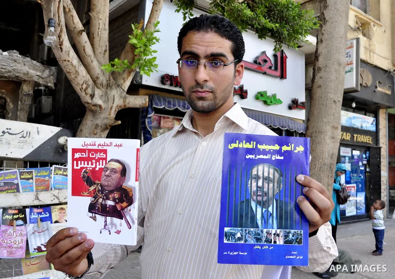 An Egyptian man looks at books and magazines with a front page picture of ousted Egyptian leader Hosni Mubarak on May 25, 2011, a day after the State prosecutor announced that Mubarak and his two sons would face trial in...