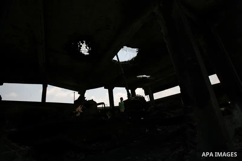 Men stand inside a building destroyed during clashes between rebel forces and Libyan Army loyal to leader Muammar Gaddafi in Misrata, Libya, May 26, 2011 Photo by Wissam Nassar