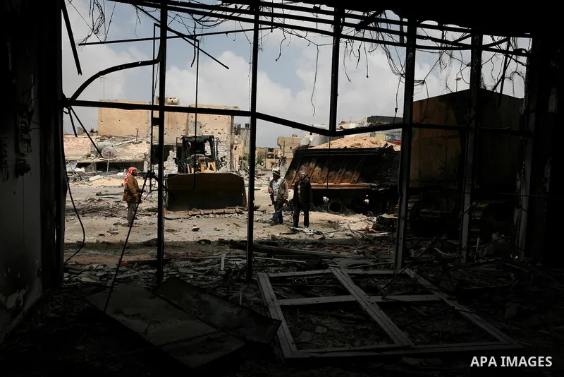 Men stand inside a building destroyed during clashes between rebel forces and Libyan Army loyal to leader Muammar Gaddafi in Misrata, Libya, May 26, 2011 Photo by Wissam Nassar