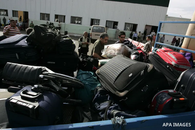Palestinians load their luggage as they wait to cross into Egypt through the Rafah border crossing in the southern Gaza Strip on May 28, 2011 as Egypt reopened the border, allowing people to cross freely for the first ti...