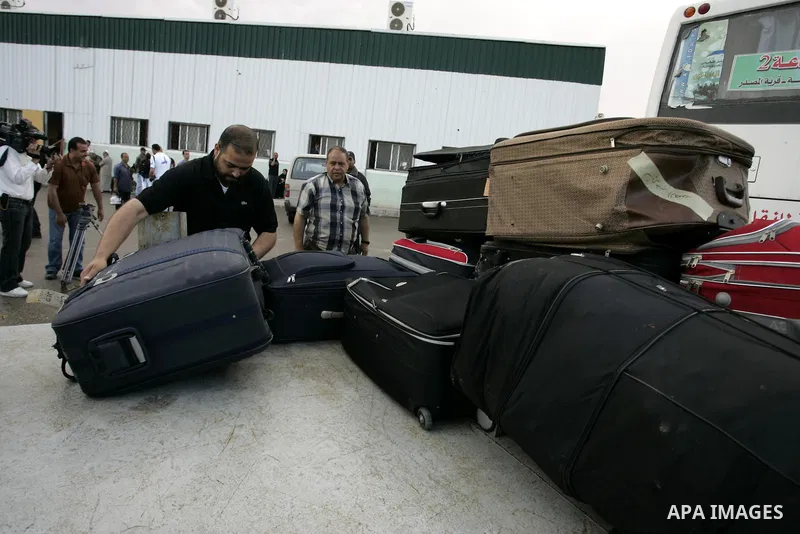 Palestinians load their luggage as they wait to cross into Egypt through the Rafah border crossing in the southern Gaza Strip on May 28, 2011 as Egypt reopened the border, allowing people to cross freely for the first ti...