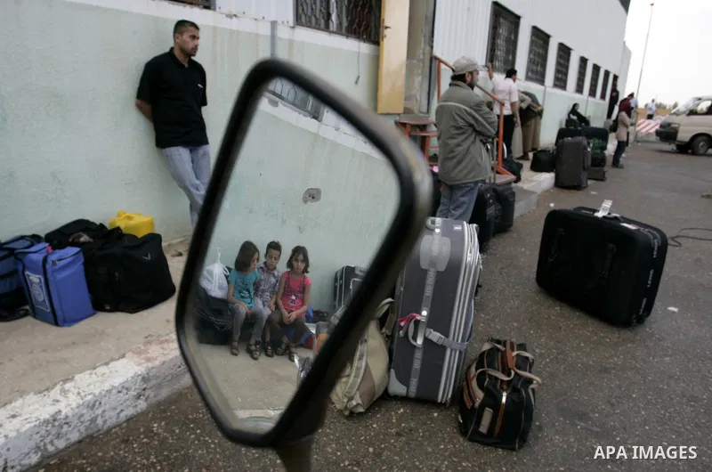 Palestinians wait to cross into Egypt through the Rafah border crossing in the southern Gaza Strip on May 28, 2011 as Egypt reopened the border, allowing people to cross freely for the first time in four years. Photo by...