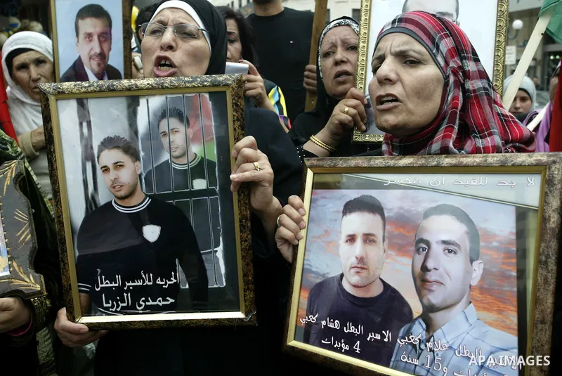 Palestinians women hold pictures of their relatives, during a protest calling for the release of Palestinian prisoners from Israeli jails, in the West Bank city of Nablus on May 28, 2011. Israel currently holds about 8,0...