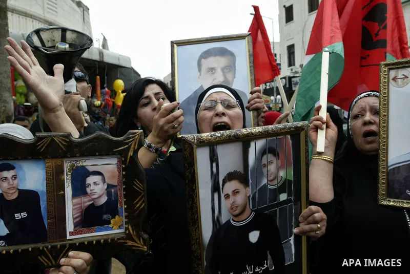 Palestinians women hold pictures of their relatives, during a protest calling for the release of Palestinian prisoners from Israeli jails, in the West Bank city of Nablus on May 28, 2011. Israel currently holds about 8,0...