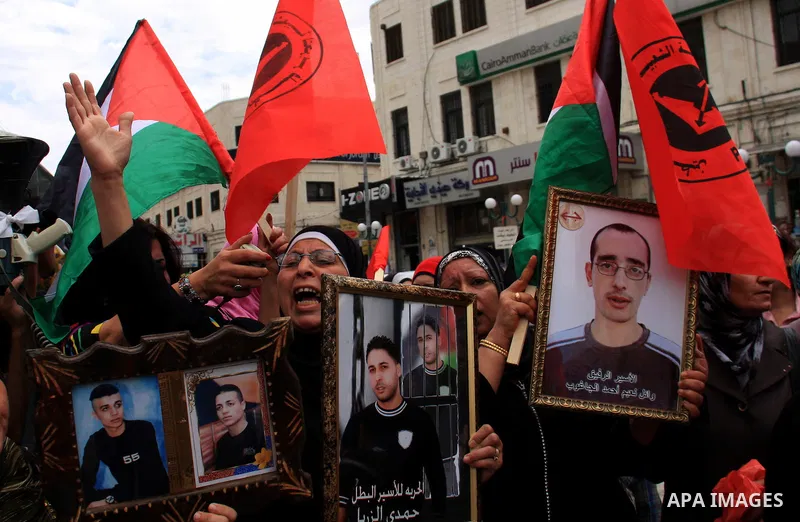 Palestinians hold pictures of their relatives, during a protest calling for the release of Palestinian prisoners from Israeli jails, in the West Bank city of Nablus on May 28, 2011. Israel currently holds about 8,000 Pal...