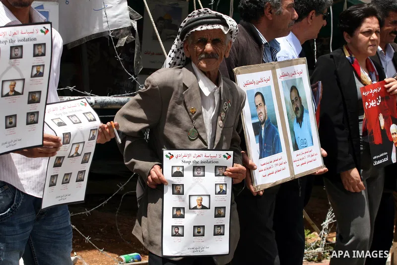 Palestinians hold banners with pictures of prisoners held in Israeli jails during a protest calling for their release, in the West Bank city of Ramallah, Saturday, May 28,2011. Photo by Issam Rimawi