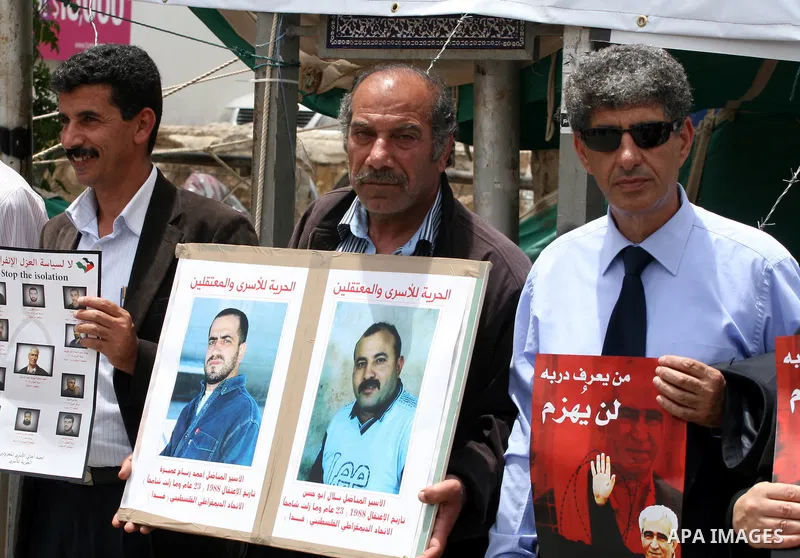 Palestinians hold banners with pictures of prisoners held in Israeli jails during a protest calling for their release, in the West Bank city of Ramallah, Saturday, May 28,2011. Photo by Issam Rimawi