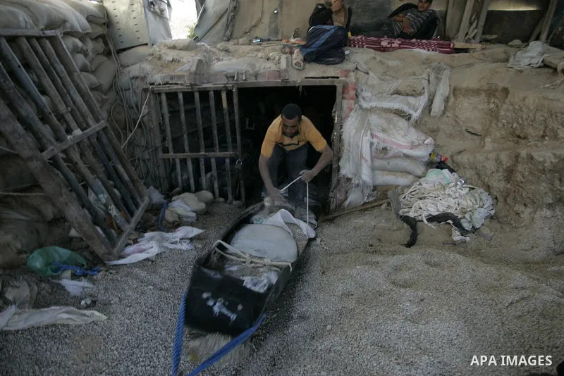 Palestinian men smuggle gravels into the Gaza Strip through a tunnel under the Egypt-Gaza border in Rafah on May 28, 2011. Egypt on Saturday reopened its Rafah border with the Gaza Strip, allowing people to cross freely...