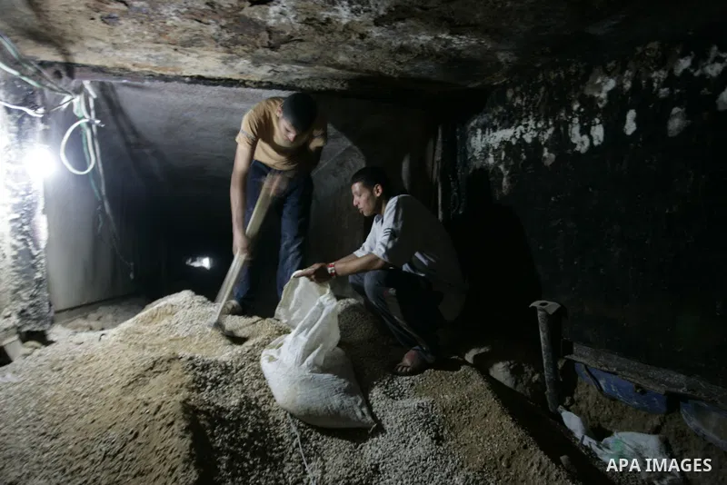 Palestinian men smuggle gravels into the Gaza Strip through a tunnel under the Egypt-Gaza border in Rafah on May 28, 2011. Egypt on Saturday reopened its Rafah border with the Gaza Strip, allowing people to cross freely...