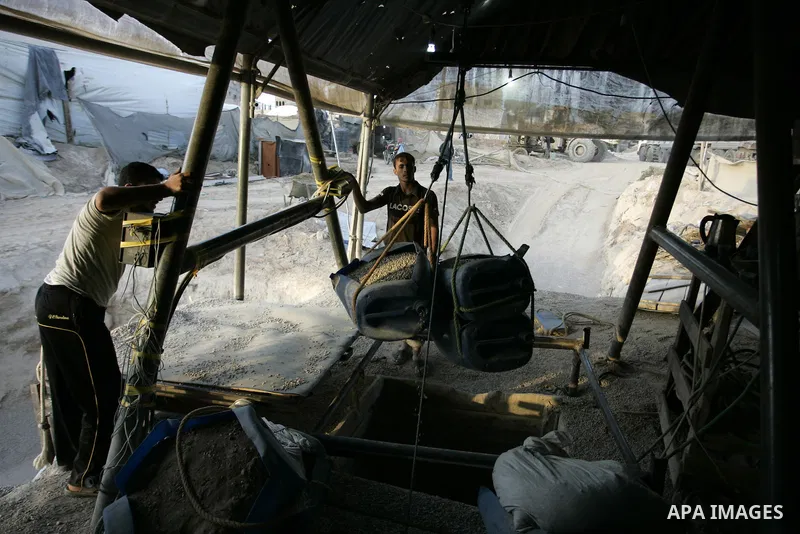 Palestinian men smuggle gravels into the Gaza Strip through a tunnel under the Egypt-Gaza border in Rafah on May 28, 2011. Egypt on Saturday reopened its Rafah border with the Gaza Strip, allowing people to cross freely...