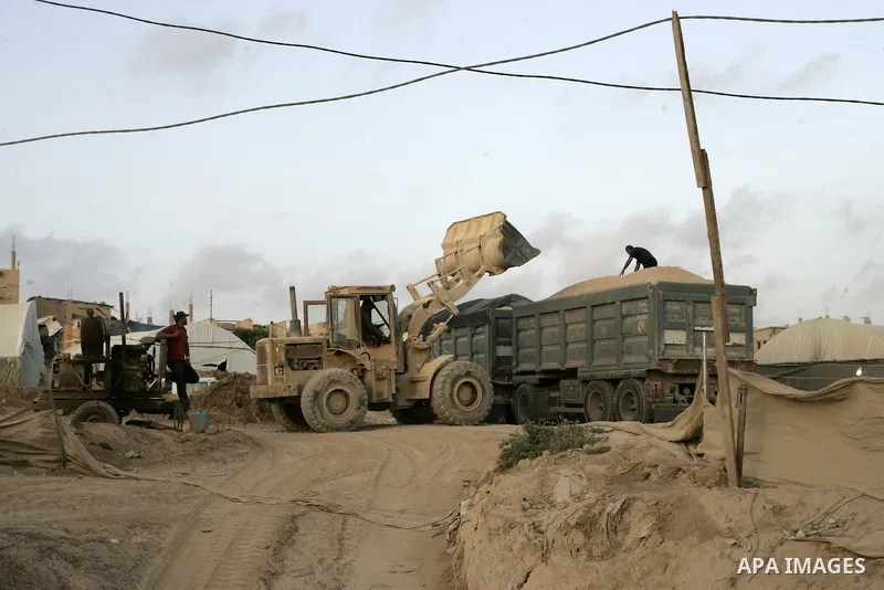Palestinian men smuggle gravels into the Gaza Strip through a tunnel under the Egypt-Gaza border in Rafah on May 28, 2011. Egypt on Saturday reopened its Rafah border with the Gaza Strip, allowing people to cross freely...
