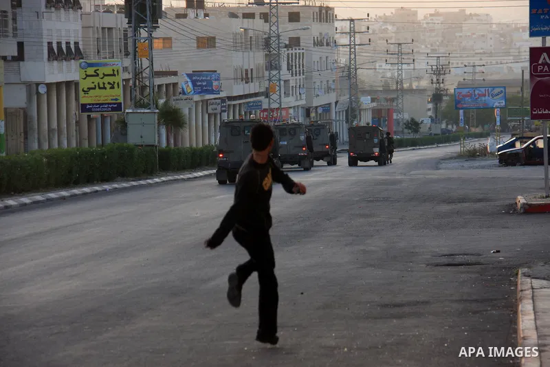 Palestinian youths throw stones at Israeli soldiers during clashes after Jews pray at the biblical Joseph's Tomb in the West Bank city of Nablus early on May 30, 2011. Photo by Wagdi Eshtayah