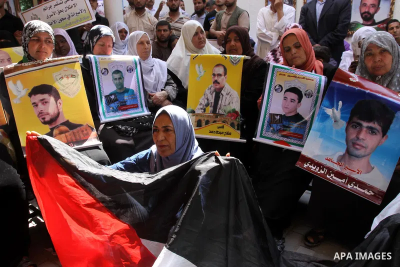 Palestinian women hold pictures of jailed relatives during a protest calling for the release of Palestinian prisoners from Israeli jails at the Red Cross office in Gaza City on May 30,2011. Photo by Mohammed Asad