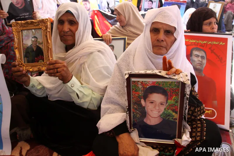 Palestinian women hold pictures of jailed relatives during a protest calling for the release of Palestinian prisoners from Israeli jails at the Red Cross office in Gaza City on May 30,2011. Photo by Mohammed Asad