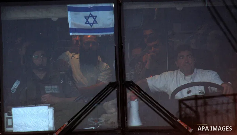 Israeli Settlers leave the biblical Joseph's Tomb after Jews pray in the West Bank city of Nablus on May 30, 2011. and the Israeli soldiers take up a positions during the clashes. Photo by Wagdi Eshtayah