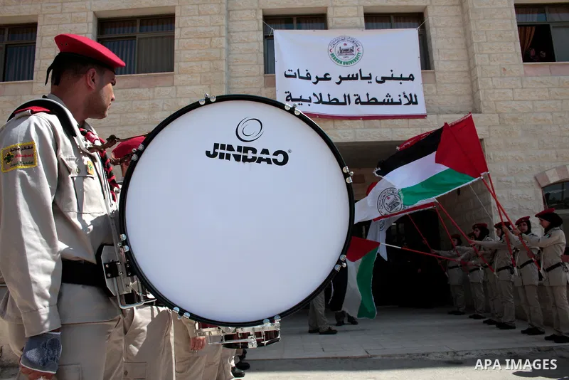 Palestinian scouts hold their national flag as Palestinian prime minister Salam Fayyad attends the opening ceremony during the inauguration of Yasser Arafat Building at Hebron University in the Palestinian city of Hebron...
