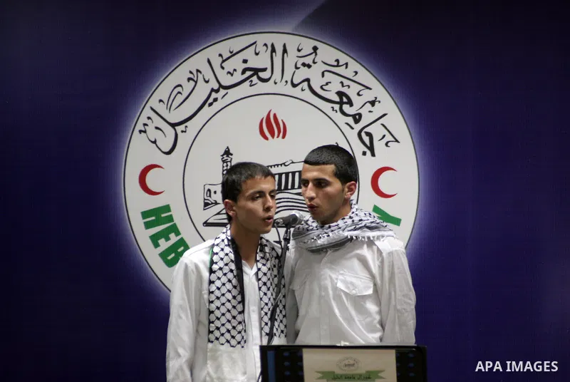 Palestinian youths sing as Palestinian prime minister Salam Fayyad attends the opening ceremony during the inauguration of Yasser Arafat Building at Hebron University in the Palestinian city of Hebron in the West Bank on...
