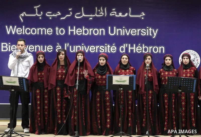 Palestinian youths sing as Palestinian prime minister Salam Fayyad attends the opening ceremony during the inauguration of Yasser Arafat Building at Hebron University in the Palestinian city of Hebron in the West Bank on...