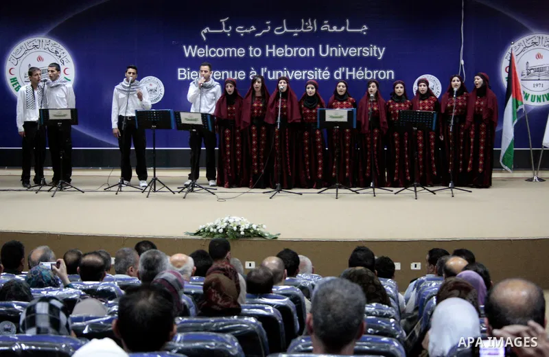 Palestinian youths sing as Palestinian prime minister Salam Fayyad attends the opening ceremony during the inauguration of Yasser Arafat Building at Hebron University in the Palestinian city of Hebron in the West Bank on...