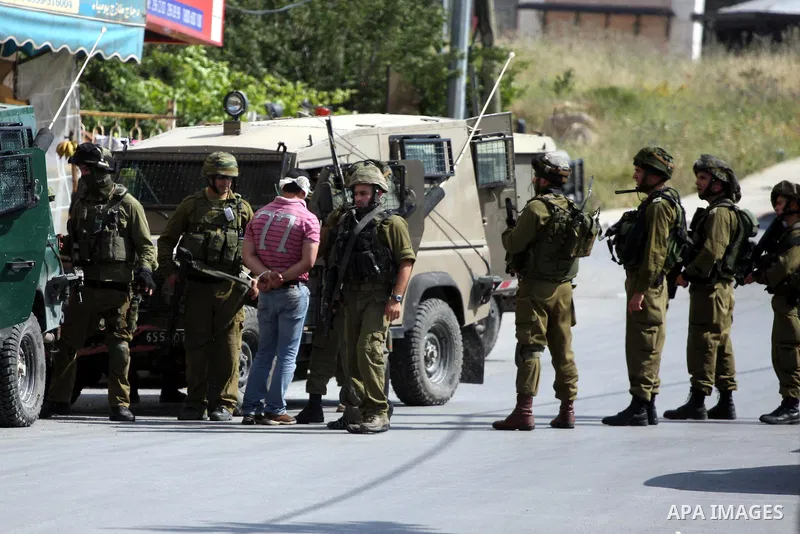 Israeli army forces arrest a man during a raid in the West Bank city of Ramallah on May 30, 2011. Five Palestinians were arrest, three from the village of Amrine, near the northern West Bank city of Nablus and two others...